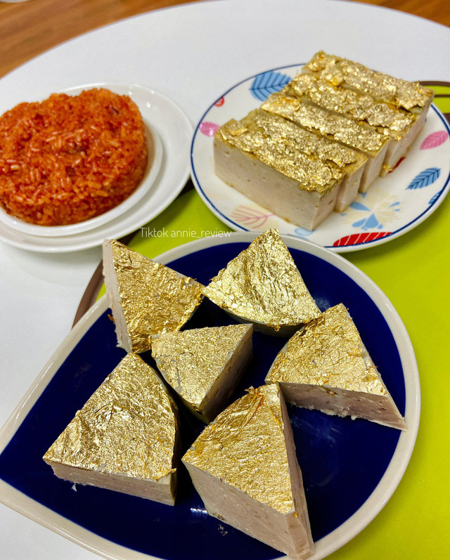 Bên cạnh các món ăn quen thuộc như cá lóc nướng, thịt heo quay, bánh hình thỏi vàng...ngày vía Thần Tài năm nay, một số gia đình còn cầu kì mua thêm giò chả dát vàng. Ảnh: TikToker @annie_review.