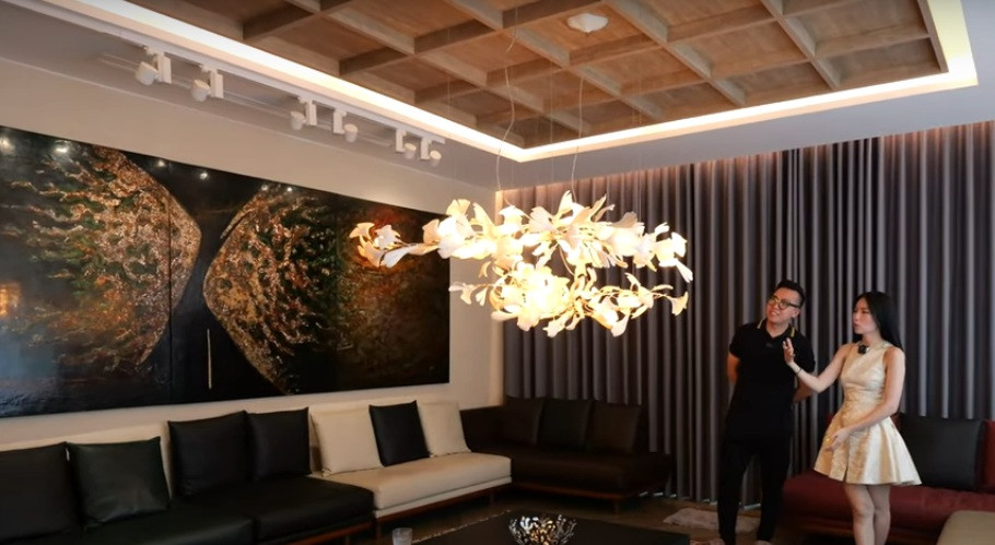 Thiết kế trần độc đáo với bộ đèn chùm thả xuống giống như bông hoa đang nở, tô điểm thêm cho không gian phòng khách.