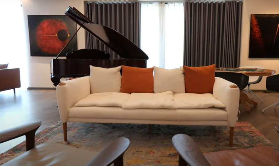 Dưới khu vực thông tầng, gia chủ đặt một bộ sofa lớn để vừa thư giãn, vừa nghe nhạc.