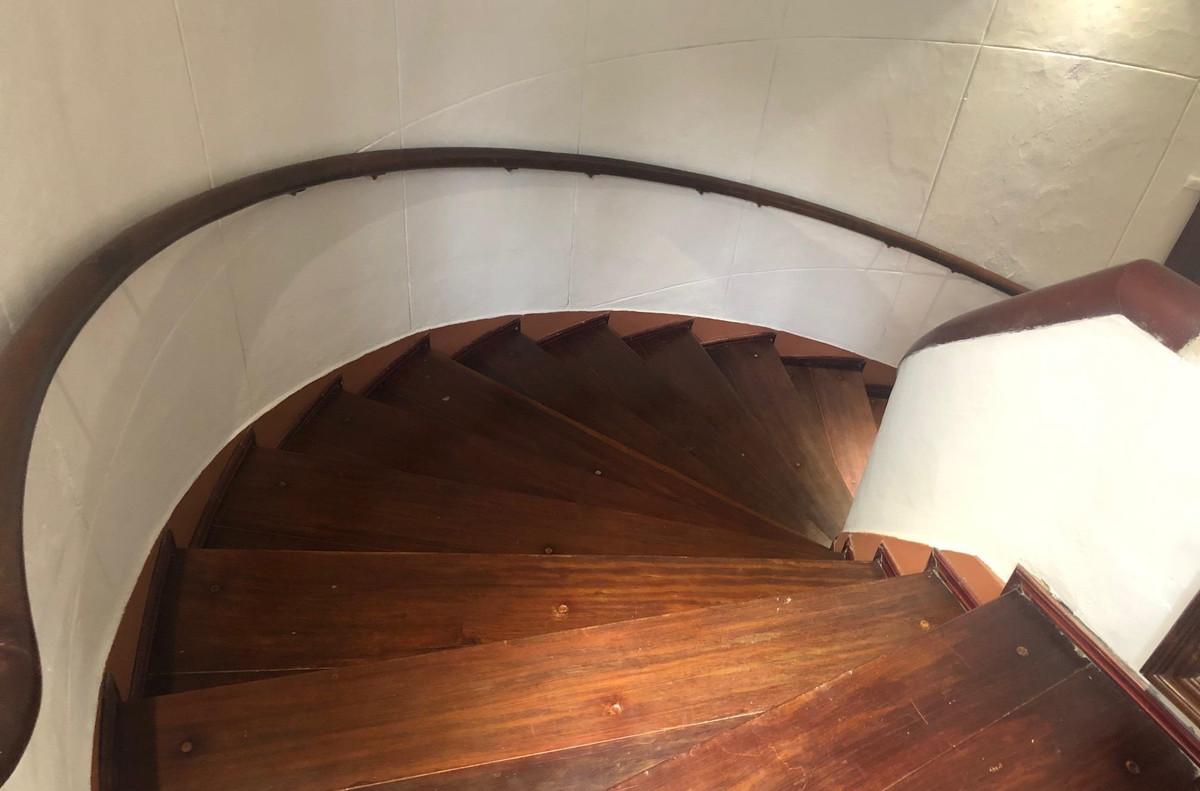 Cầu thang gỗ uốn lượn cách điệu, với phần tay vịn được xây chắc chắn bằng gạch và viền gỗ. Ảnh: Nhandan