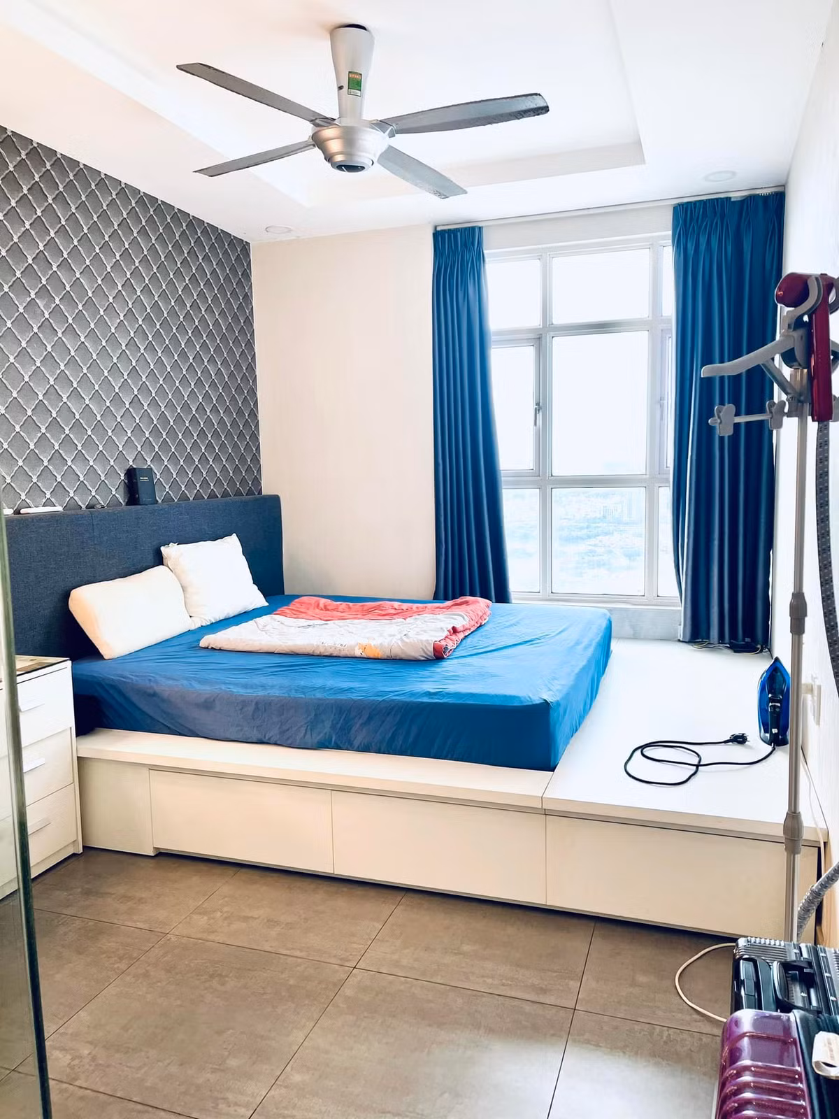 Phòng ngủ chính trong căn hộ dễ chịu với màu xanh - trắng.