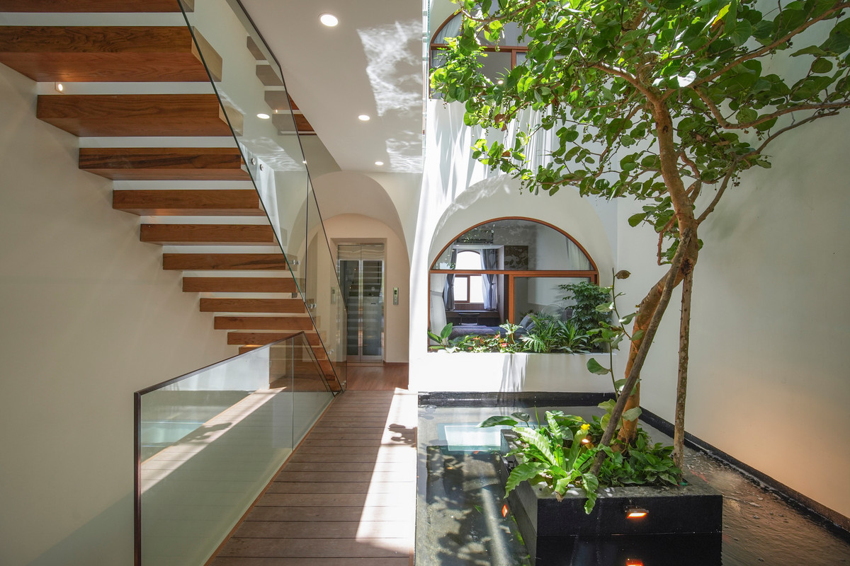 Giữa hai khu vực phòng khách, phòng ngủ là hồ cá và không gian cây xanh gần gũi với thiên nhiên hơn.