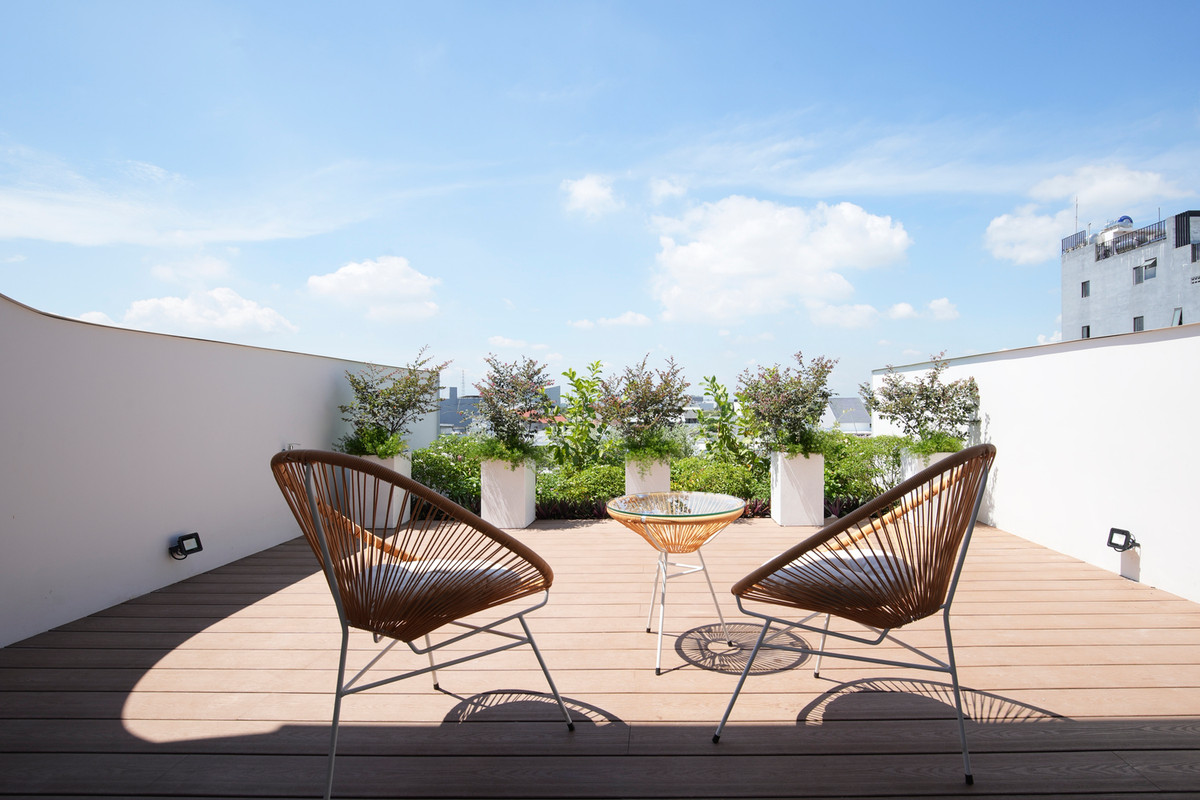 Ở không gian này, kiến trúc sư sử dụng cây xanh và sàn gỗ như một cách để chống nóng cho các tầng dưới