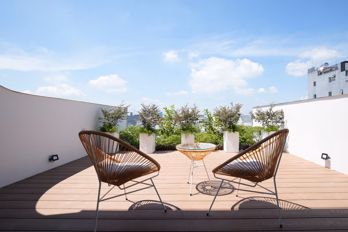 Ở không gian này, kiến trúc sư sử dụng cây xanh và sàn gỗ như một cách để chống nóng cho các tầng dưới