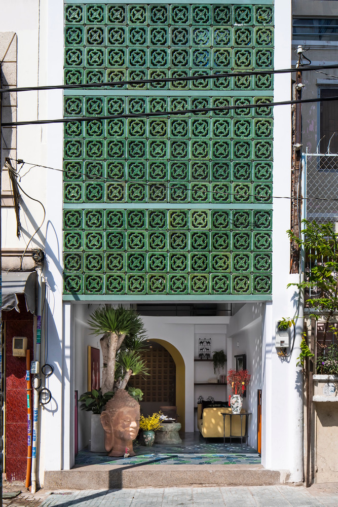 Điểm nhấn bên ngoài mặt tiền là khối tường gốm màu xanh lục, vừa tạo giúp lưu thông không khí, vừa đảm bảo tính riêng tư.