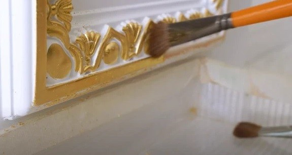 Sau khi phủ kín vàng, người thợ dùng bút lông để đánh bóng.