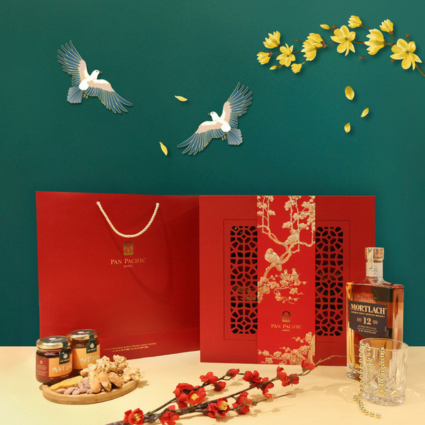 Hộp quà Tết "Hỷ Tước Đăng Mai" của khách sạn Pan Pacific Hanoi có điểm nhấn là bức tranh chim khách đậu cành mai đậm chất thơ, kết hợp cùng bao bì đỏ rực rỡ. Ảnh: Pan Pacific Hanoi