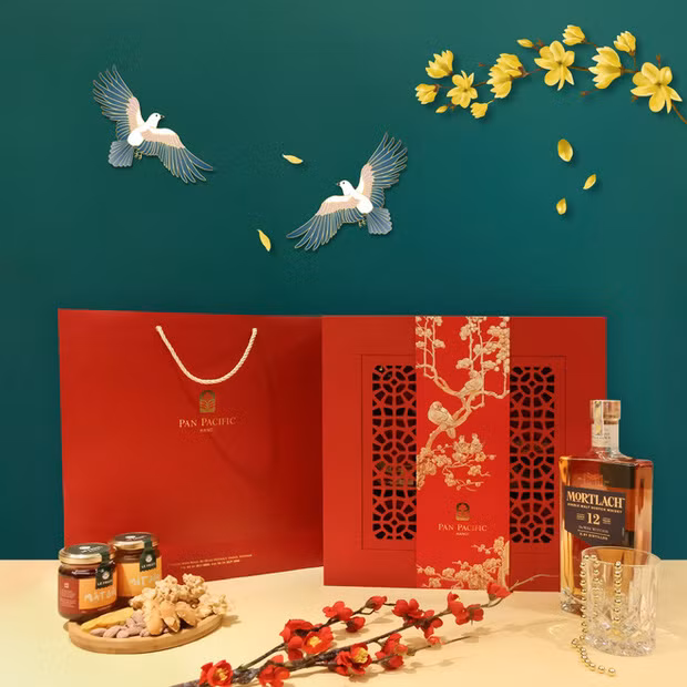 Hộp quà Tết "Hỷ Tước Đăng Mai" của khách sạn Pan Pacific Hanoi có điểm nhấn là bức tranh chim khách đậu cành mai đậm chất thơ, kết hợp cùng bao bì đỏ rực rỡ. Ảnh: Pan Pacific Hanoi