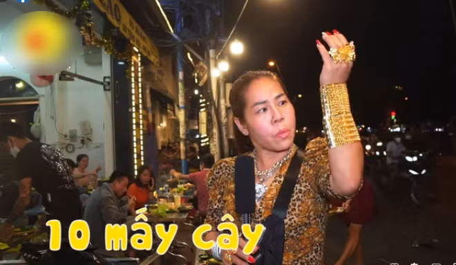 Cách đây không lâu, mạng xã hội xôn xao về một người phụ nữ đeo trên người hơn 70 cây vàng chỉ để... đứng bán hàng. Ảnh chụp màn hình