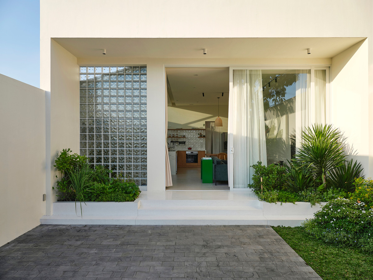 Mặt tiền của ngôi nhà được bao phủ bởi cây xanh và hòa mình với thiên nhiên.