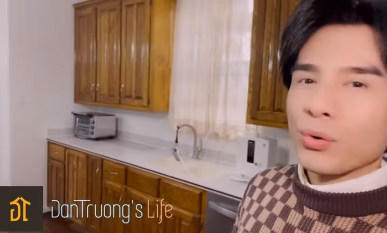 Phòng bếp trong nhà Đan Trường có nhiều tủ, giúp không gian gọn gàng và thoáng đãng. Ảnh chụp màn hình