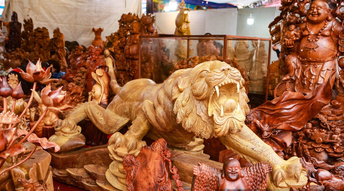 Tại chợ hoa xuân nằm tại khu vực quảng trường phía trước cổng sân vận động quốc gia Mỹ Đình (Nam Từ Liêm, Hà Nội), một tác phẩm hổ chế tác bằng gỗ mun được rao bán với giá 115 triệu đồng khiến nhiều người sửng sốt. Ảnh: Dân Việt