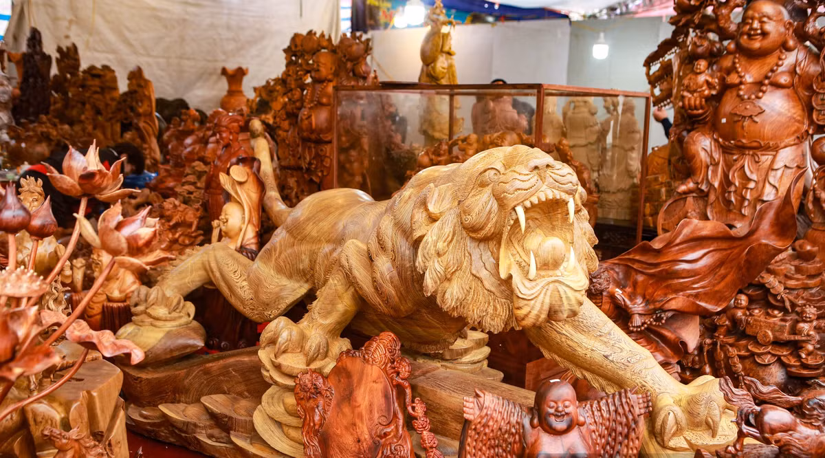 Tại chợ hoa xuân nằm tại khu vực quảng trường phía trước cổng sân vận động quốc gia Mỹ Đình (Nam Từ Liêm, Hà Nội), một tác phẩm hổ chế tác bằng gỗ mun được rao bán với giá 115 triệu đồng khiến nhiều người sửng sốt. Ảnh: Dân Việt