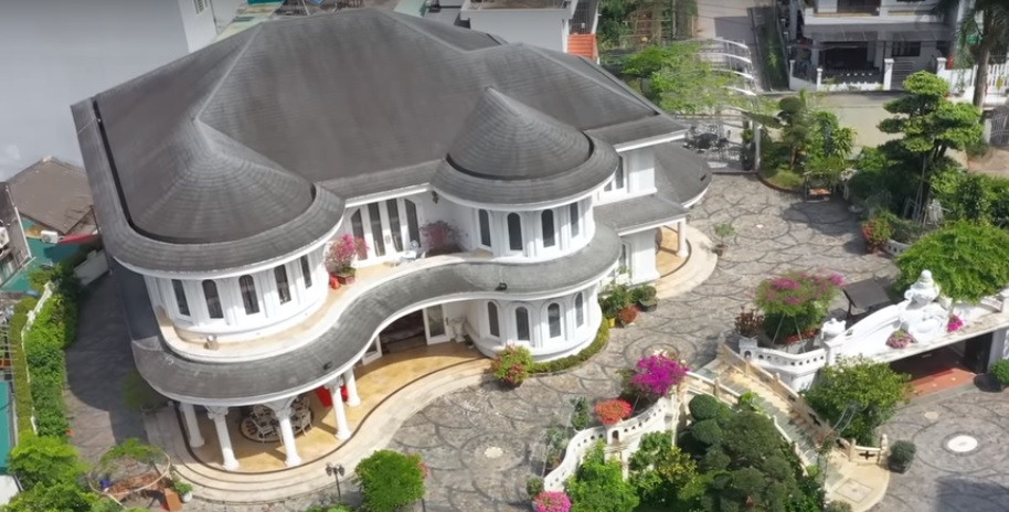 Qua cầu thang là một khoảng sân phía trước ngôi nhà với rất nhiều cây và hoa. Căn nhà được thiết kế với rất nhiều đường cong.