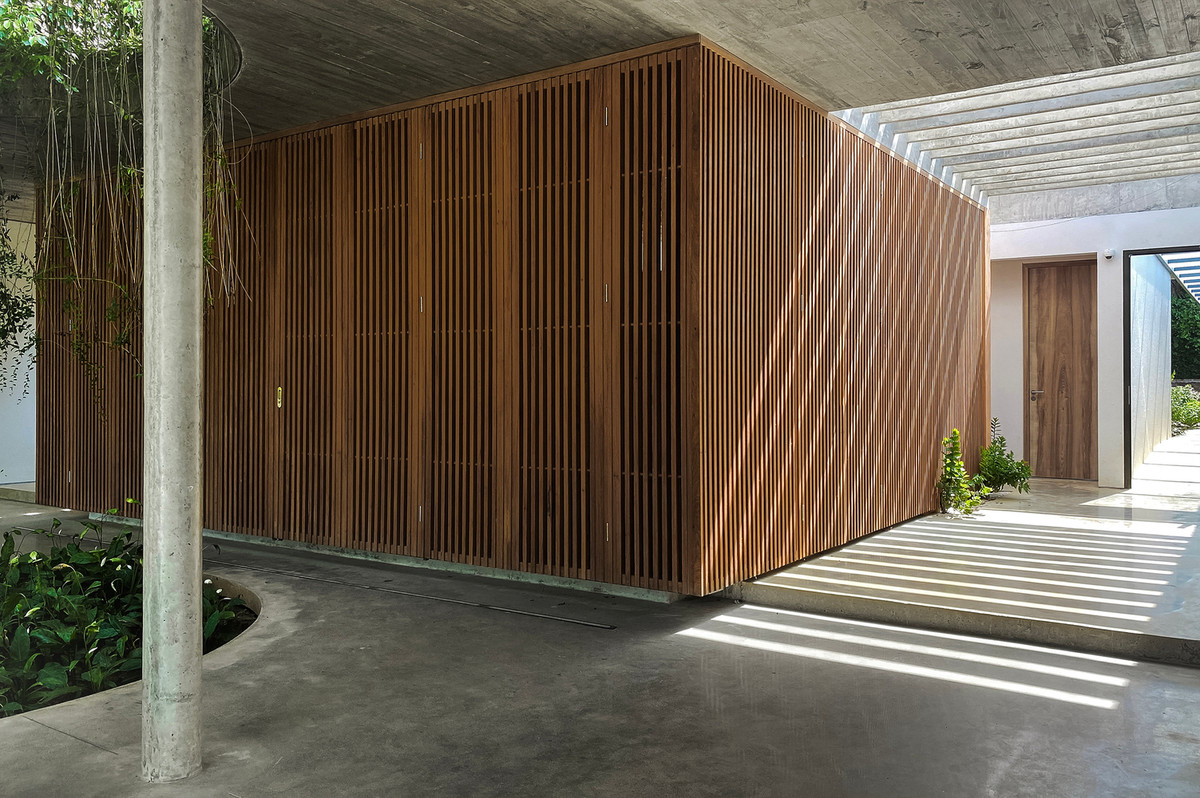 Thay cho cửa gỗ đóng kín truyền thống, nhóm kiến trúc sư thiết kế các thanh gỗ đan nhau cho lớp cửa vừa tạo sự riêng tư cần thiết nhưng vẫn đảm bảo việc lưu thông.