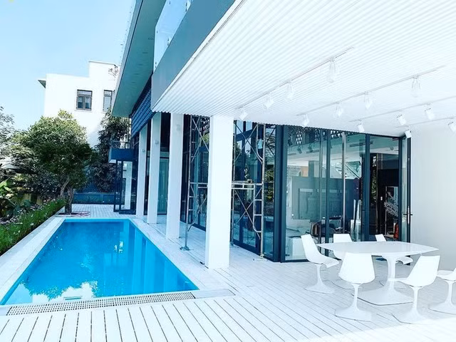 Phía ngoài biệt thự là không gian hồ bơi và cây vườn. Ảnh: FBNV