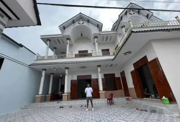 Nhà mới của gia đình Dụng Quang Nho rộng rãi, sử dụng tone màu trắng là chủ đạo, cửa nhà được làm toàn bộ bằng gỗ. Ảnh: FBNV