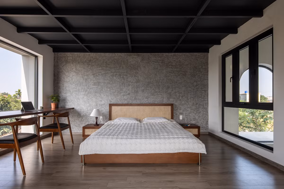 Phòng ngủ thiết kế tối giản, một bàn làm việc được đặt ngay trong căn phòng hướng tầm nhìn về phía cách đồng xanh mát. Nguồn ảnh: Hoang Le