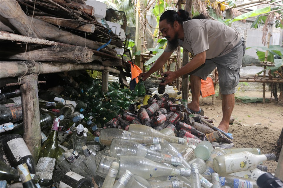Năm 2006, ông Linh xây ngôi nhà rộng 5 m, dài 18 m, có 20 trụ bê tông, nhưng mới xong phần thô, thiếu tiền hoàn thiện. Năm 2016, thấy Hội An có nhiều nhà hàng vứt bỏ chai thủy tinh, sẵn có tay nghề xây dựng, ông nảy sinh ý tưởng tận dụng để xây dựng nhà bằng chai có thể thêm phần tiết kiệm cho gia đình. Ảnh: Lao động