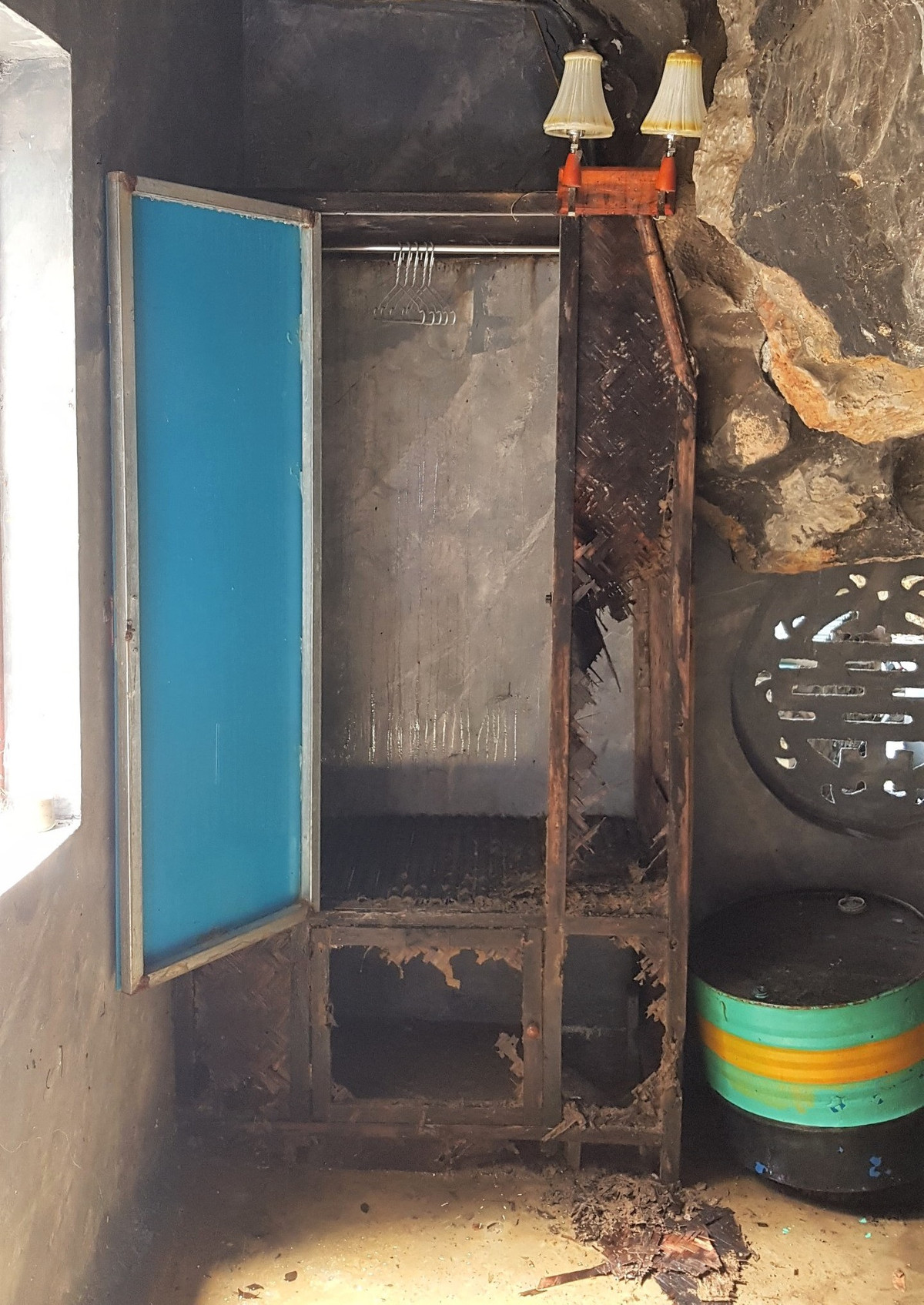 Không còn giường đệm, đèn điện lộng lẫy như quảng cáo, toàn bộ hang rộng hơn 20m2 ẩm thấp, được chia thành 2 ngăn. Trong đó, ngăn chính không có gì ngoài chiếc thùng phuy cũ, chiếc tủ mục nát. Ảnh: Dân trí