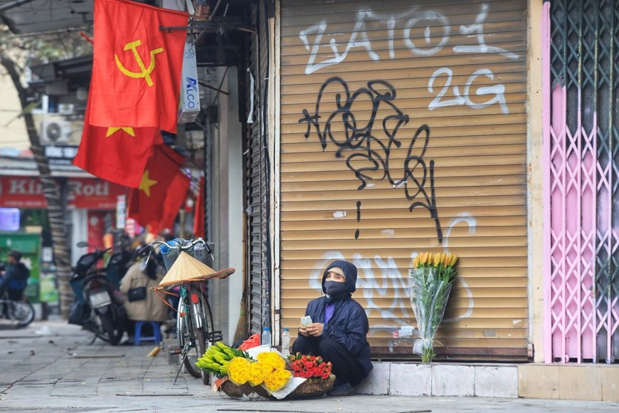 Một người bán hoa hàng rong bán hàng ngày đầu năm. (Ảnh: Tuấn Anh/TTXVN)