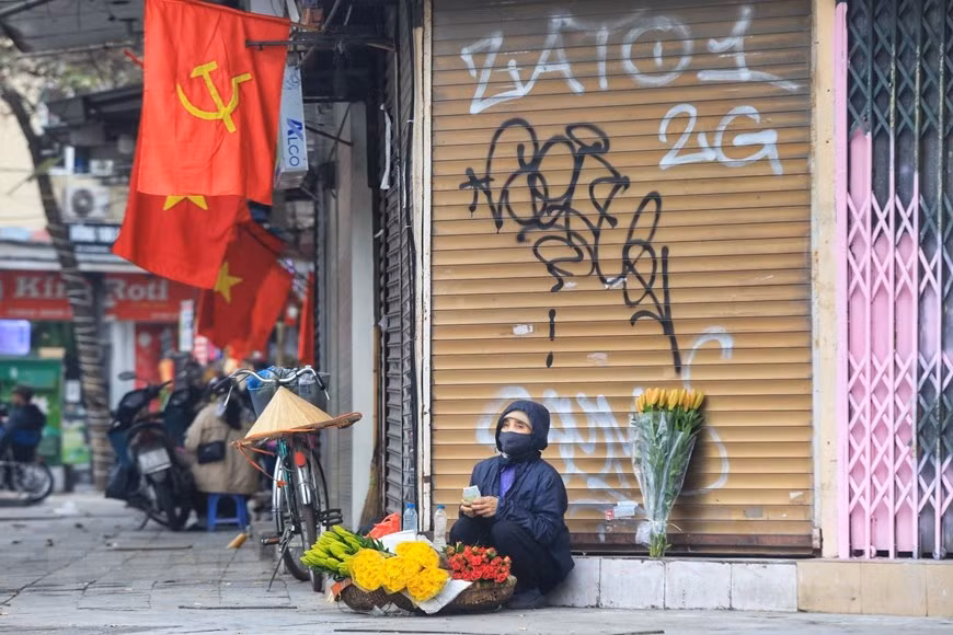 Một người bán hoa hàng rong bán hàng ngày đầu năm. (Ảnh: Tuấn Anh/TTXVN)