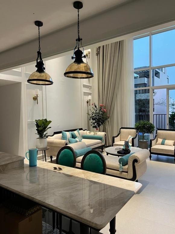 Phòng khách bài trí cổ điển, sang trọng với sofa tông trầm dài và một chiếc tivi cỡ lớn. Ảnh: FBNV