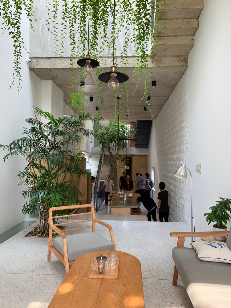 Để chắn nắng, khói bụi và thông gió tự nhiên xuyên suốt chiều dài ngôi nhà, kiến trúc sư thiết kế mặt tiền hai lớp kết hợp với một lớp cây xanh.