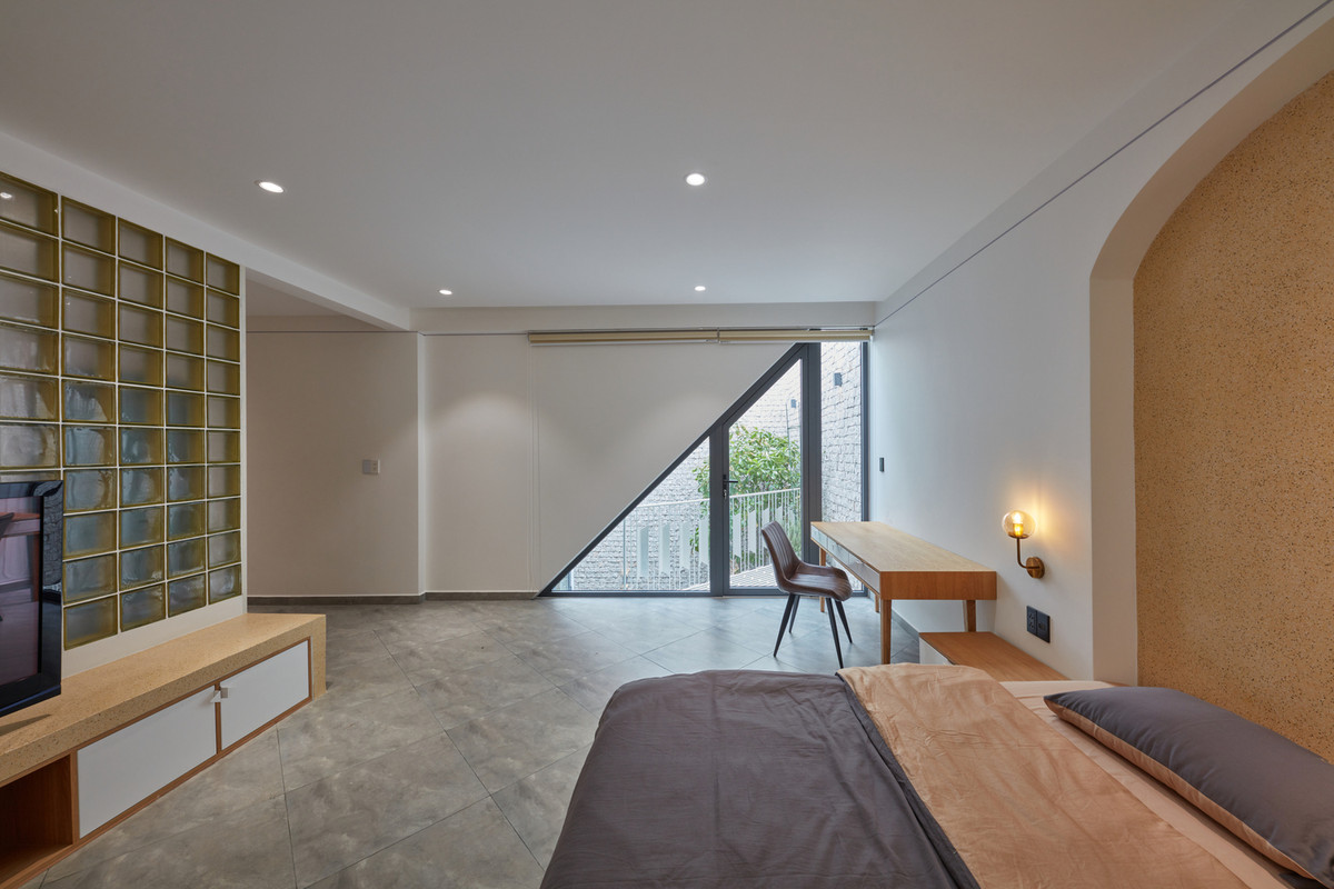 Không gian phòng ngủ rộng rãi với một cửa sổ có tạo hình tam giác đồng nhất với tổng thể công trình.