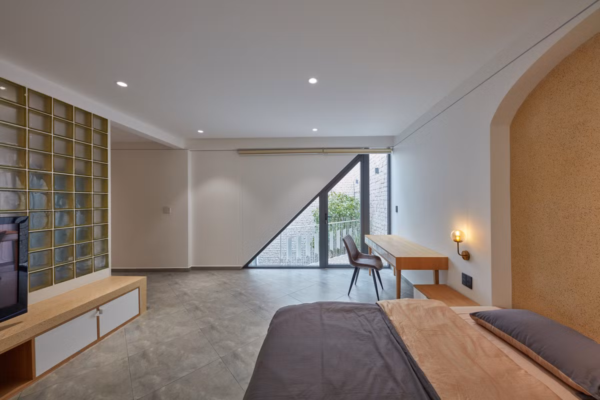 Không gian phòng ngủ rộng rãi với một cửa sổ có tạo hình tam giác đồng nhất với tổng thể công trình.