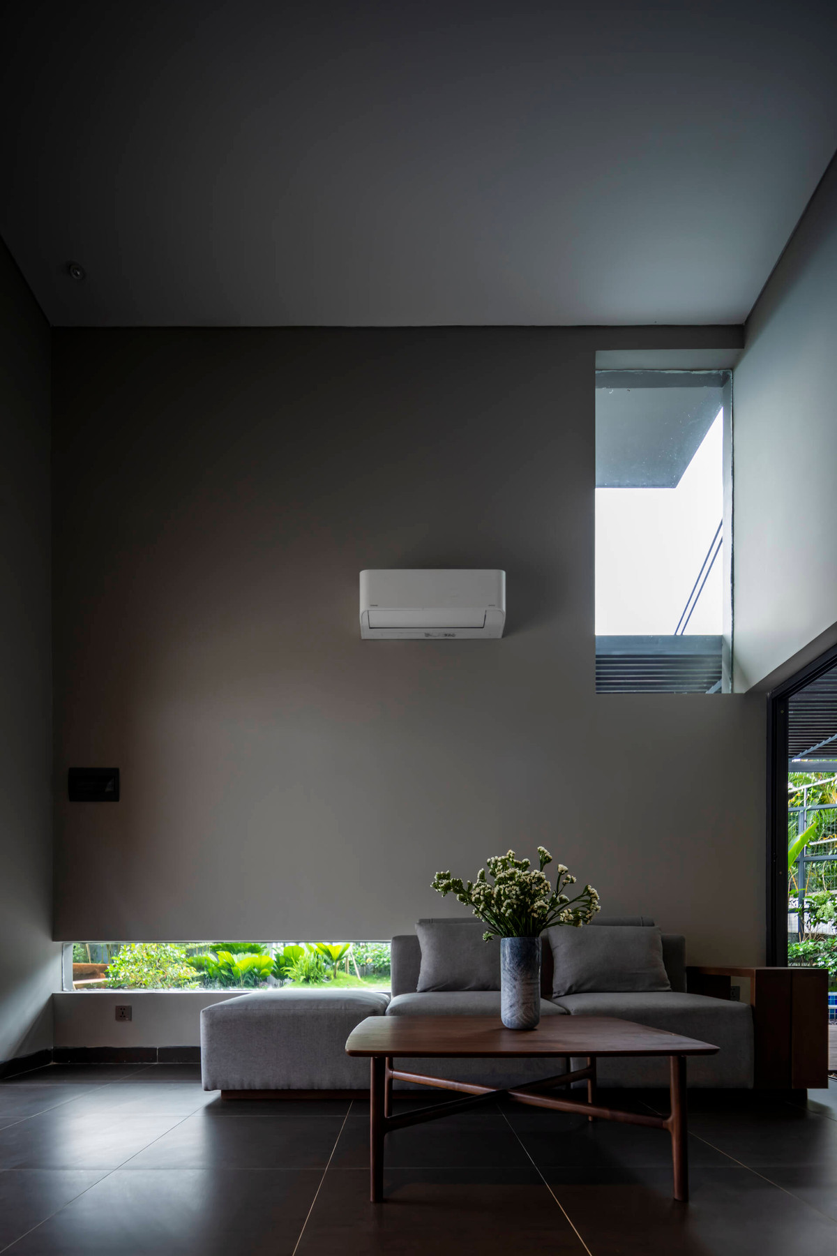 Phòng khách thiết kế tối giản nhưng tràn ngập ánh sáng tự nhiên từ những ô kính.