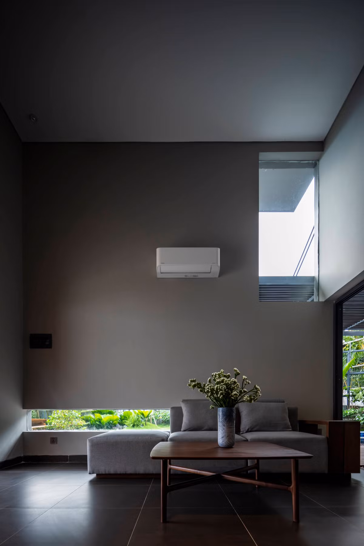 Phòng khách thiết kế tối giản nhưng tràn ngập ánh sáng tự nhiên từ những ô kính.