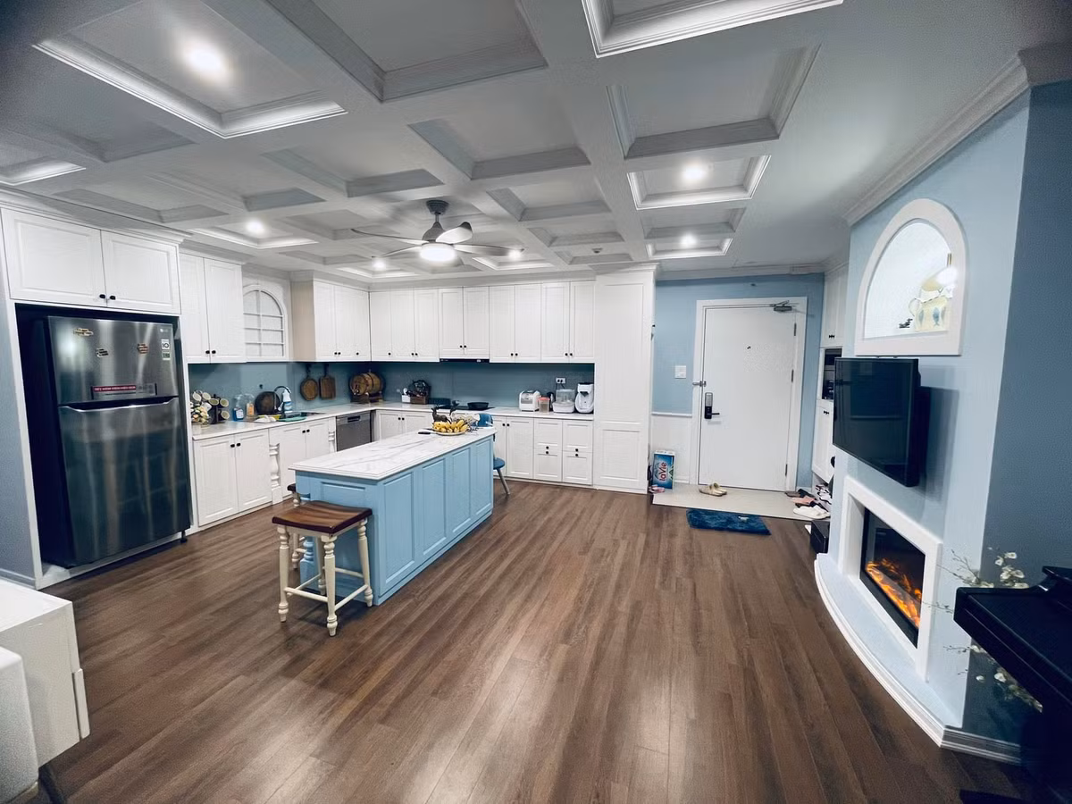 Phòng bếp nổi bật với gam màu trắng và đảo bếp màu xanh là điểm nhấn.