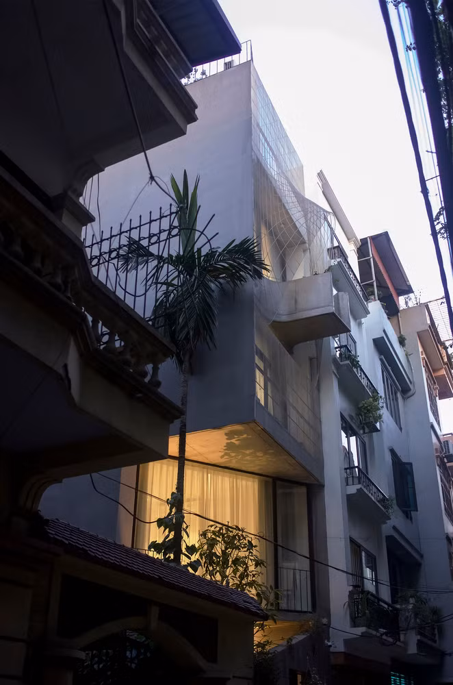 Mặt tiền được thiết kế vát chéo để tạo giếng trời, đồng thời nới rộng không gian cho phần hiên mang lại nhiều ánh sáng cho sân trước.