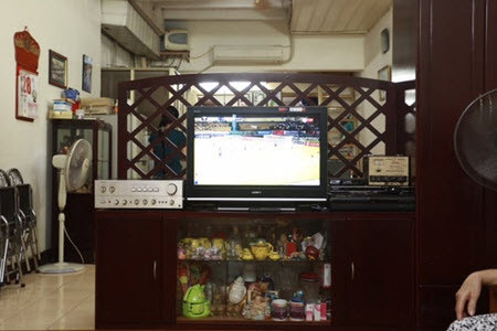 Phòng khách và bếp đuọc ngăn bằng một vách gỗ đơn giản. Ảnh: Dân Việt