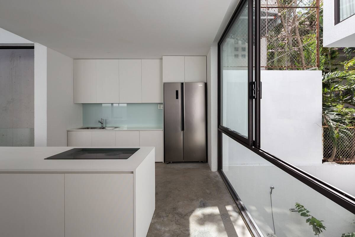 Từ nhà bếp cũng có thể nhìn ra khu vườn trong nhà nhờ cửa sổ kính lớn.
