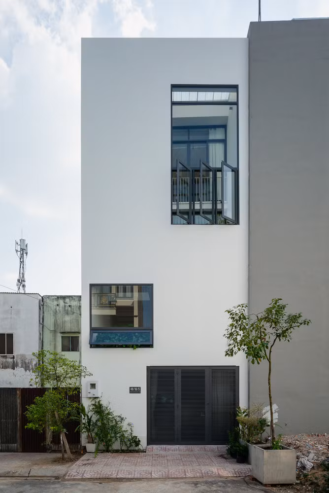 Mặt tiền với những ô cửa sổ lớn trên cao giúp ngôi nhà luôn tràn ngập ánh sáng, thông thoáng nhưng vẫn đảm bảo sự riêng tư. Nguồn ảnh: Quang Tran