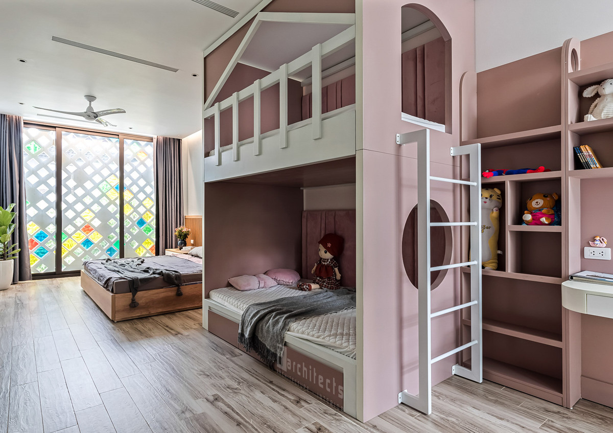 Giường ngủ của cha mẹ và giường tầng của bé được đặt liền kề trong một không gian, tạo sự tương tác gần gũi khi các thành viên trong gia đình nghỉ ngơi.