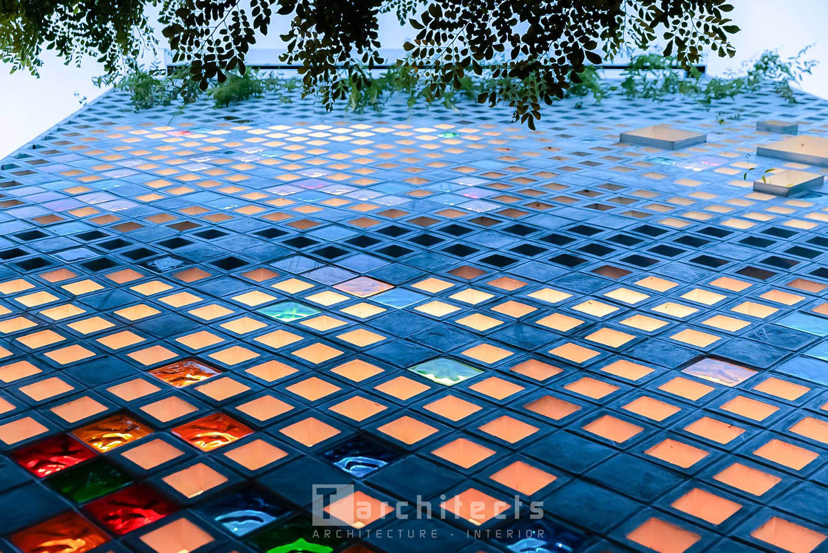 Với ý tưởng tạo ra điểm nhấn độc đáo trên bề mặt công trình, kiến trúc sư sử dụng gạch thông gió vuông kết hợp với gạch kính nhiều màu sắc.