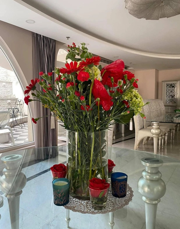 Phòng khách được bài trí thoáng đãng với nhiều hoa tươi.