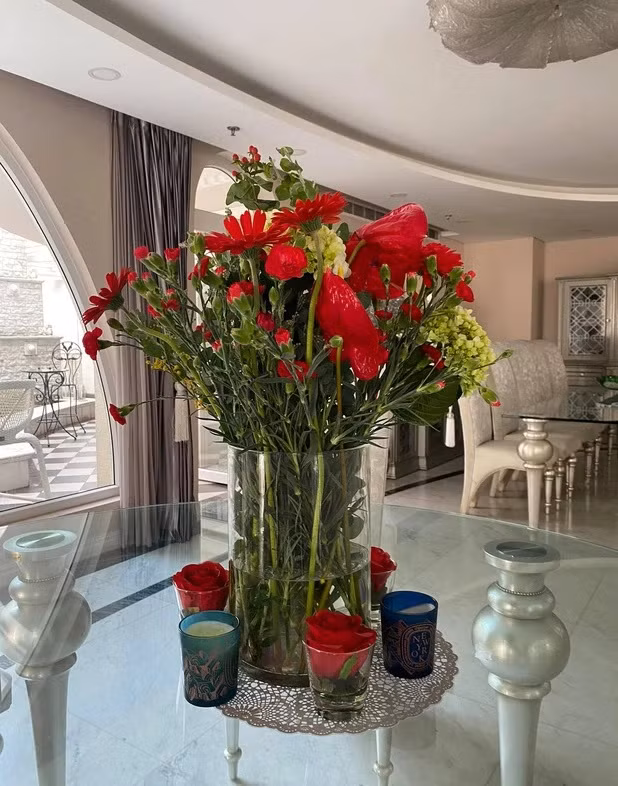 Phòng khách được bài trí thoáng đãng với nhiều hoa tươi.