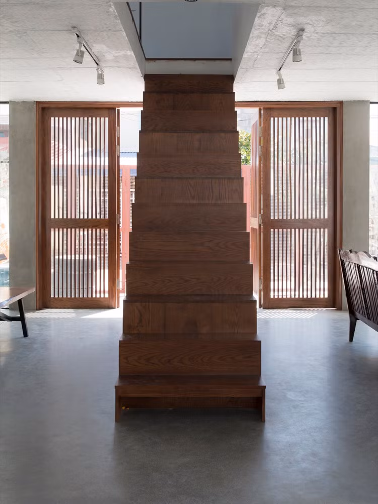 Ngay lối cửa vào nhà là một cầu thang bằng gỗ.