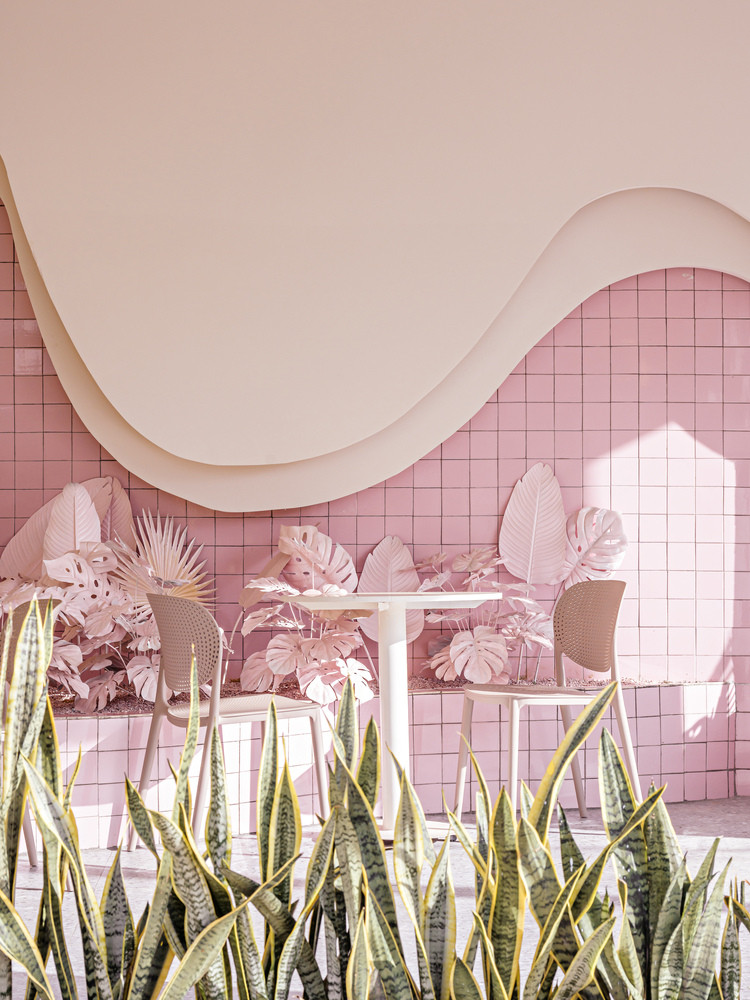 Sự kết hợp thú vị giữa màu sắc và chất liệu, như gạch kính hay đèn silicone kéo dài trên trần nhà, và cây cảnh phủ màu đồng tạo nên hiệu ứng mạch lạc xuyên suốt cho toàn bộ thiết kế.