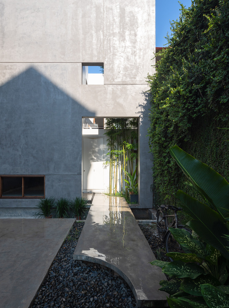 Sân thứ nhất được bố trí theo lối thông thường (dọc theo trục dài của khu đất) một góc 90 độ. Nhóm thiết kế đặt cửa chính vừa kín đáo, tinh tế, vừa tránh được ánh nắng trực tiếp của hướng tây.