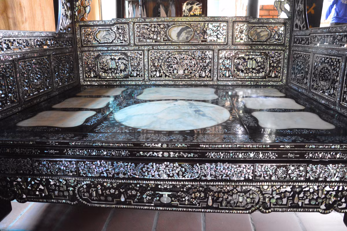 Chiếc giường này trên 100 năm tuổi, có chiều dài khoảng 2,5m, rộng 2m được làm từ gỗ gõ. Ảnh: Dân Việt