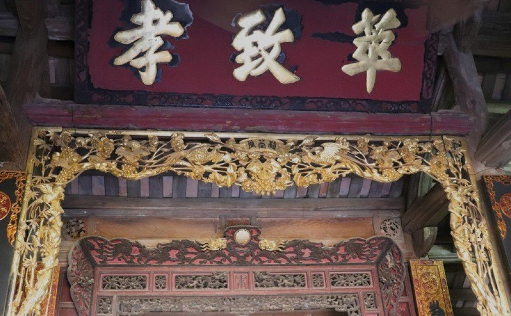 Bức thiều châu cùng với ba chữ “Hiếu - Trí - Hoa” sơn son thiếp vàng được gia đình ông Hùng coi như bảo vật. Ảnh: VOV