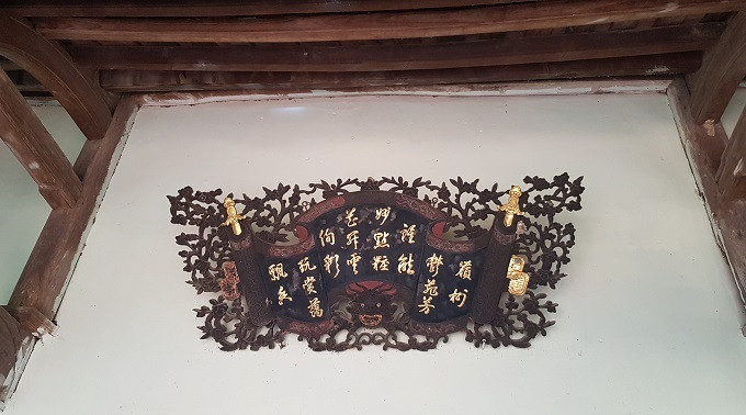 Phía ngoài cửa chính là bức cuốn thư cổ. Một số họa tiết trên bức cuốn thư cũng được dát vàng. Ảnh: Vietnamnet