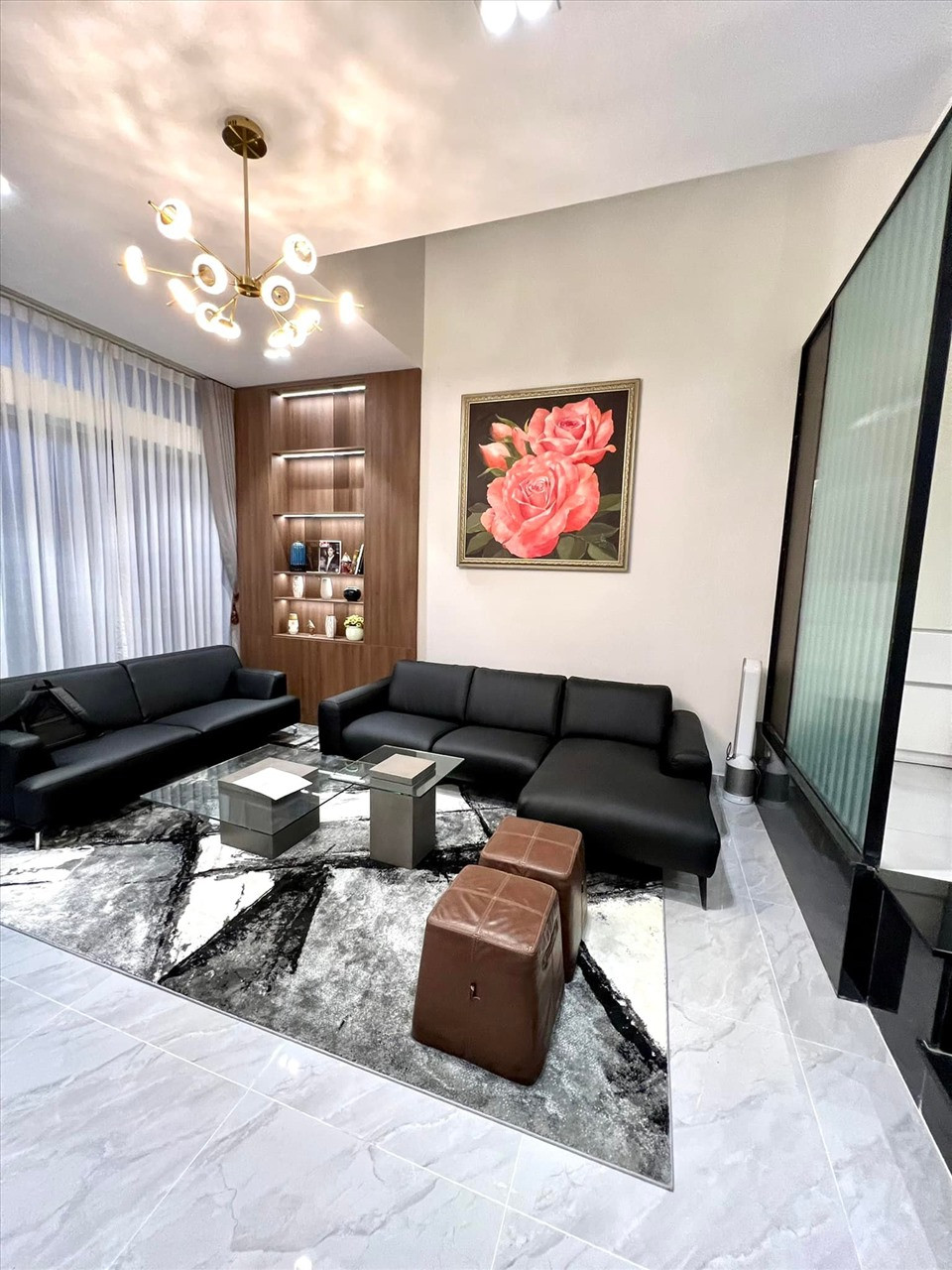 Phòng khách với sofa lớn màu đen, có cửa sổ lớn tạo sự thông thoáng. Ảnh: FBNV