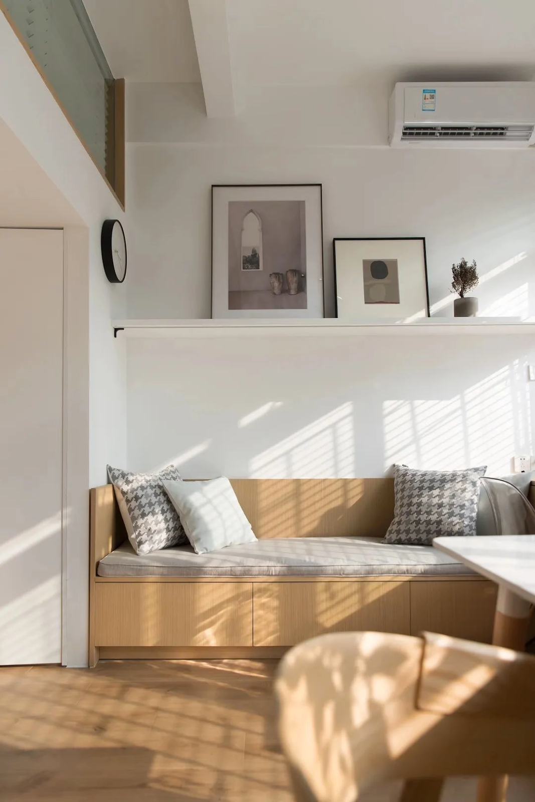 Phía sau công trình phụ là không gian sinh hoạt chính tràn ngập ánh sáng từ cửa sổ.