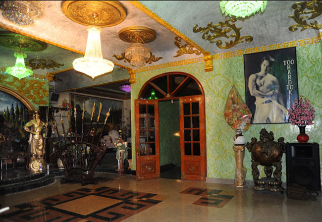 Đằng sau bức tượng và chiếc ghế gỗ lớn là bộ binh khí dễ khiến khách giật mình trong lần đầu ghé thăm. Ảnh: Khám phá